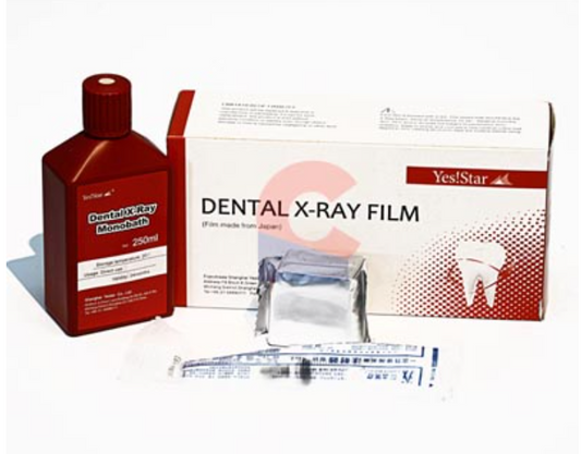 Dental X-ray film kit with a bottle of developer and syringes on a white background