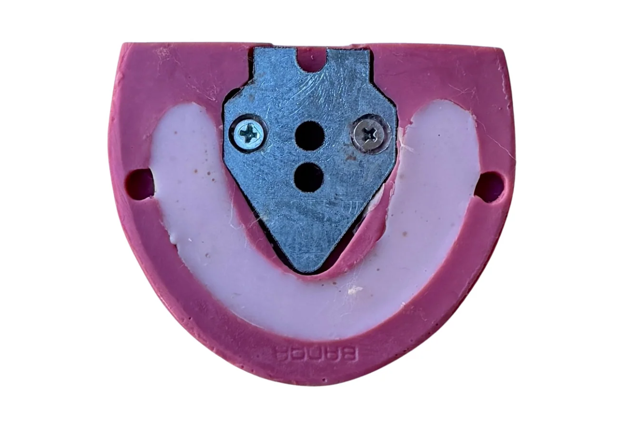 Pink and blue mechanical component on a white background