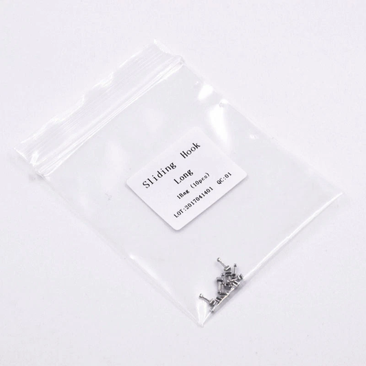 Small metal component in a clear plastic bag with a label on a white background