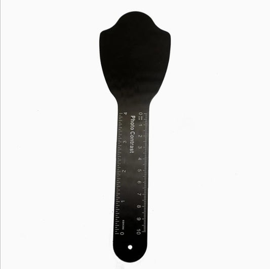 Black spatula with measurement scale on a white background