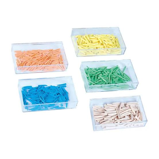 Set of colorful toothpicks in clear plastic containers on a white background