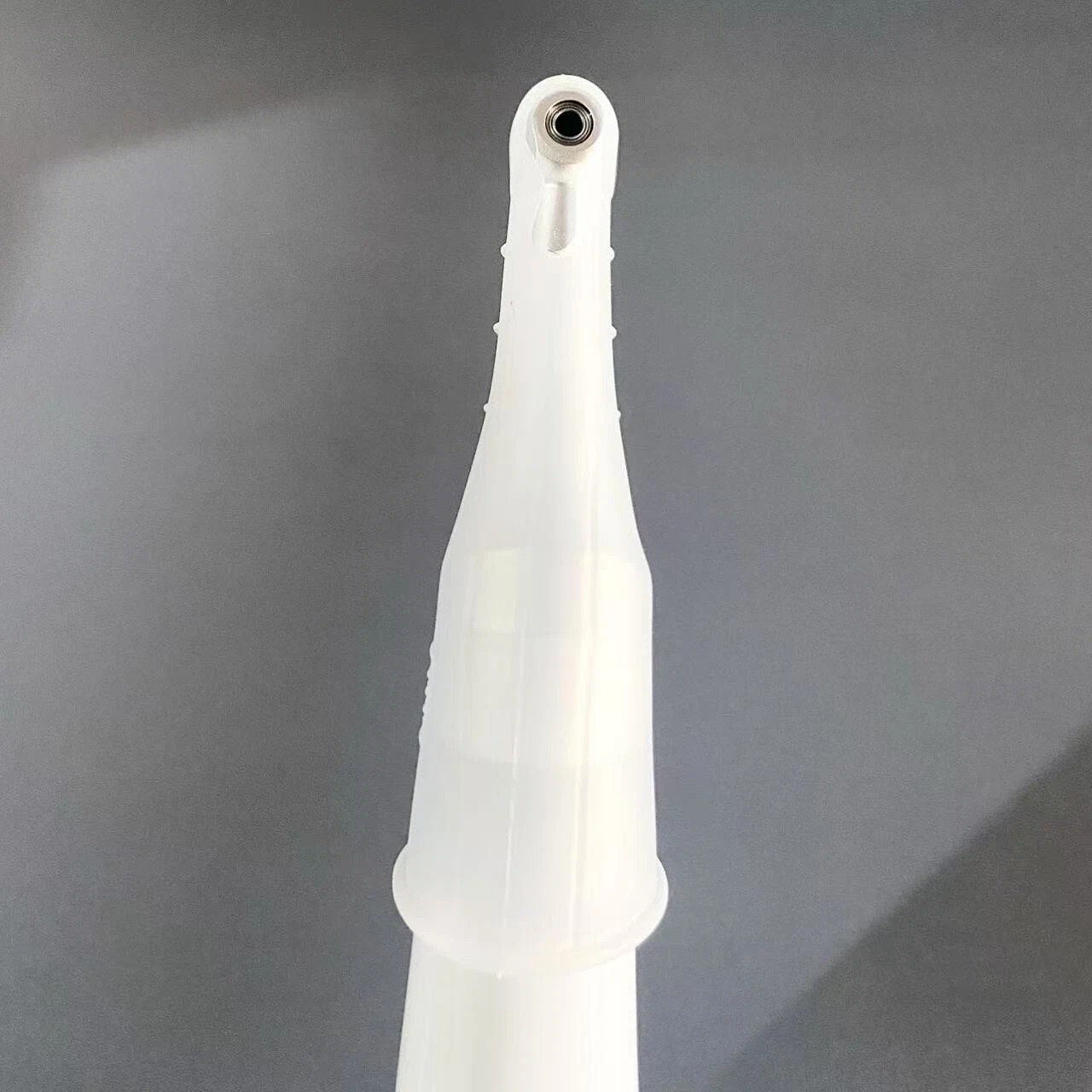 White dental tool on a gray background